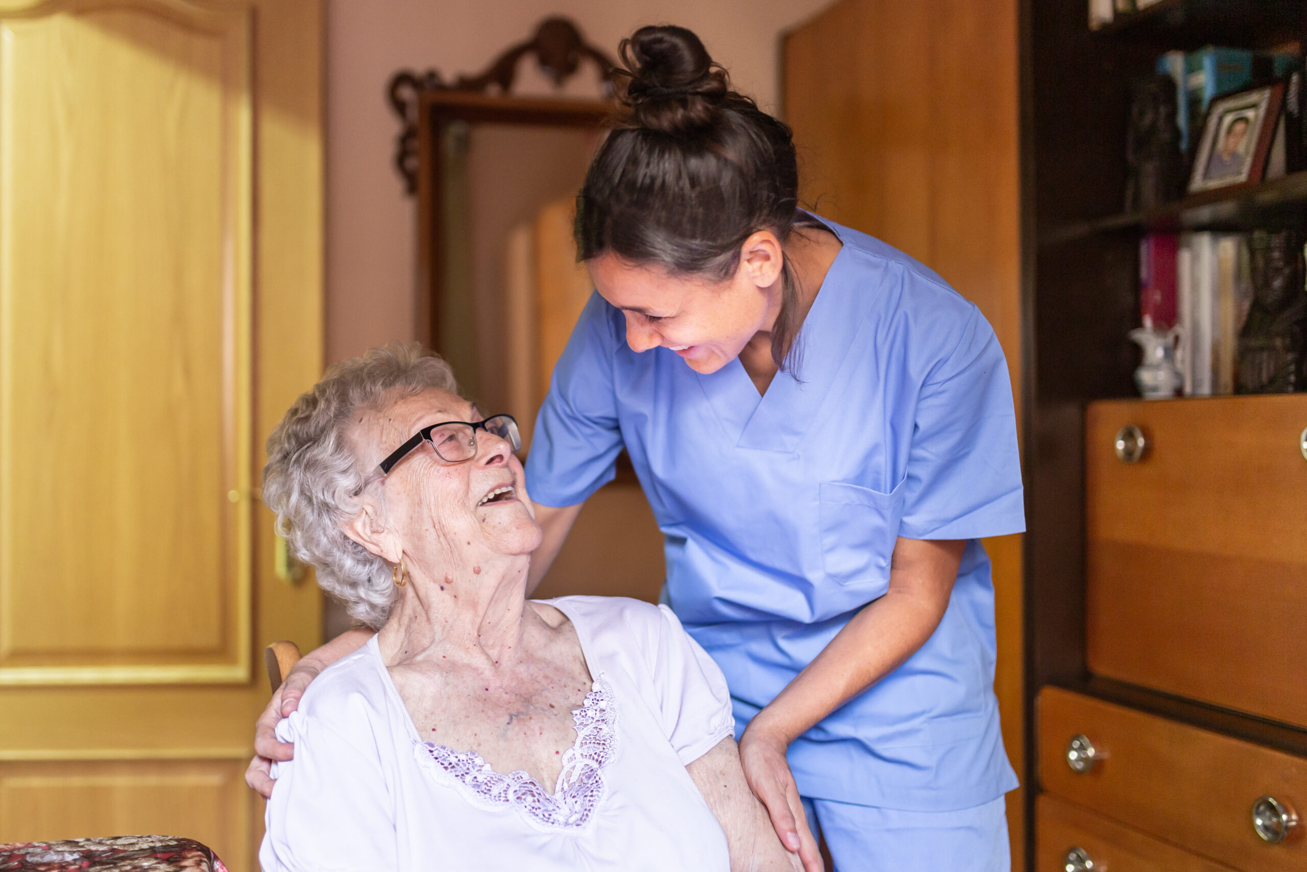 Happy Senior woman laughing with her caregiver at home. Senior